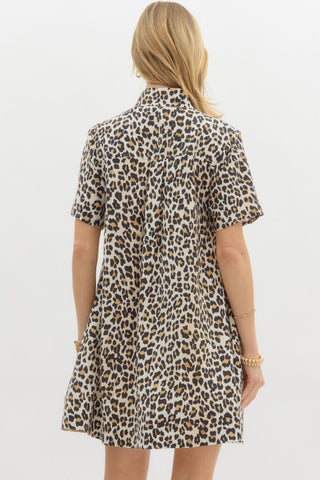 Leopard print short sleeve pullover mini dress featuring multicolor high band collar front half button closure. Pockets at sides. Lined. Woven. Non-sheer. Lightweight.