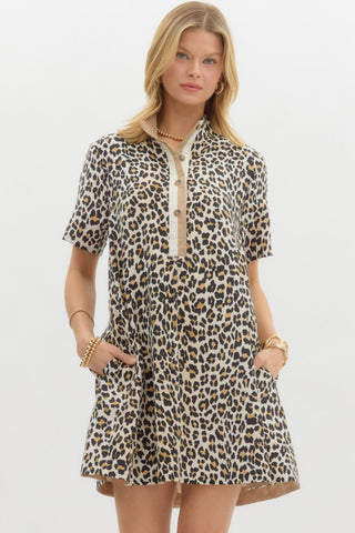 Leopard print short sleeve pullover mini dress featuring multicolor high band collar front half button closure. Pockets at sides. Lined. Woven. Non-sheer. Lightweight.