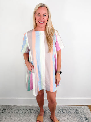 Multicolor striped round neck short sleeve mini swing dress featuring pocket at front. Back neck keyhole button closure. Lined. Woven. Non-sheer. Lightweight.