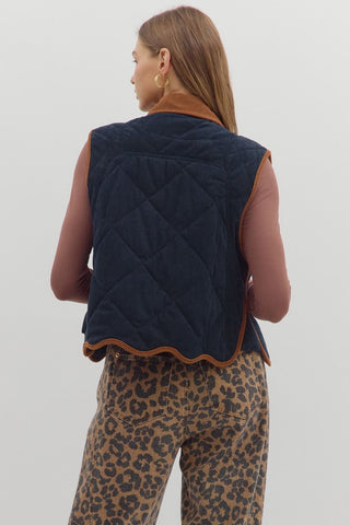 Solid sleeveless quilted corduroy quilted vest featuring contrast accent scallop hem and collar. Snap button front closure. Front pockets. Lined. Woven. Non-sheer. Lightweight.