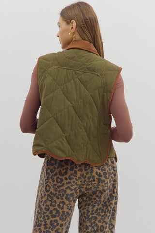 Solid sleeveless quilted corduroy quilted vest featuring contrast accent scallop hem and collar. Snap button front closure. Front pockets. Lined. Woven. Non-sheer. Lightweight.