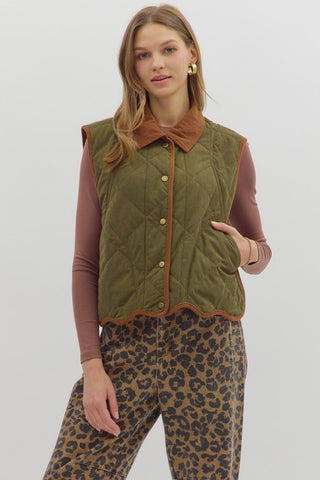 Solid sleeveless quilted corduroy quilted vest featuring contrast accent scallop hem and collar. Snap button front closure. Front pockets. Lined. Woven. Non-sheer. Lightweight.