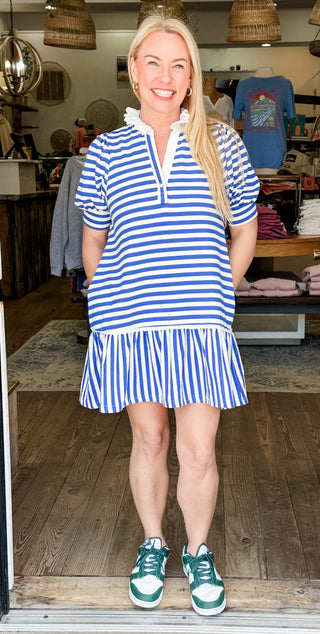 Blue and white striped dress with a notched neckline, puff sleeves, and a tiered ruffle hem.