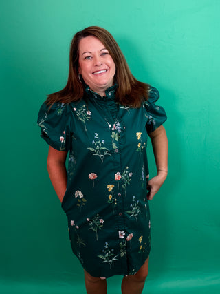 Floral print short bubble sleeve mini dress featuring ruffle accent band collar button front closure. Side pockets. Lined. Woven. Non-sheer. Lightweight.