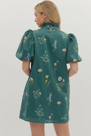 Floral print short bubble sleeve mini dress featuring ruffle accent band collar button front closure. Side pockets. Lined. Woven. Non-sheer. Lightweight.