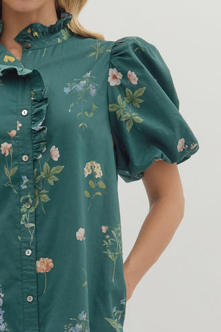 Floral print short bubble sleeve mini dress featuring ruffle accent band collar button front closure. Side pockets. Lined. Woven. Non-sheer. Lightweight.