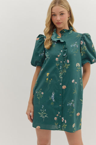 Floral print short bubble sleeve mini dress featuring ruffle accent band collar button front closure. Side pockets. Lined. Woven. Non-sheer. Lightweight.