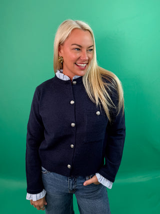 Solid long sleeve sweater knit cardigan featuring striped contrast ruffle details. Button front closure. Knit. Woven. Non-sheer. Lightweight.