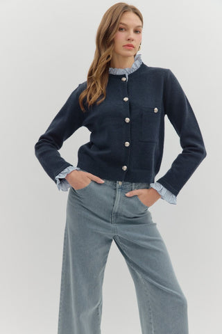 Solid long sleeve sweater knit cardigan featuring striped contrast ruffle details. Button front closure. Knit. Woven. Non-sheer. Lightweight.