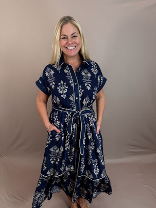 Botanical pattern faux roll-up sleeve band midi dress featuring striped accent piping trim inset. Collar button closure at front with removable belt. Side pockets. Lined. Woven. Non-sheer. Lightweight.