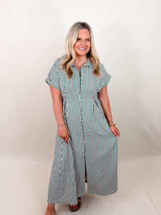Striped short sleeve midi dress featuring shirt collar, pleated waist seam. Side pockets. Button closure at front. Zipper at side. Lined. Woven. Non-sheer. Lightweight.