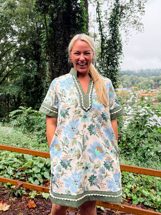 Floral print short shirt sleeve mini dress featuring contrast inset caftan- inspired neck band. Side pockets. Lined. Woven. Non-sheer. Lightweight.