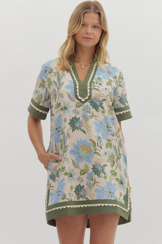 Floral print short shirt sleeve mini dress featuring contrast inset caftan- inspired neck band. Side pockets. Lined. Woven. Non-sheer. Lightweight.
