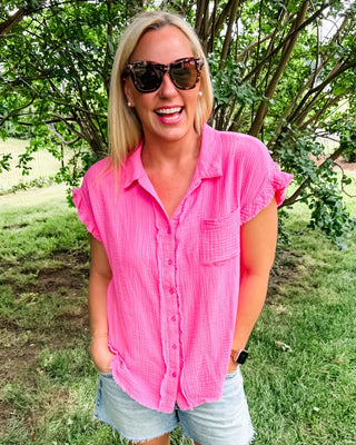 Vibrant pink button up top with short ruffle sleeve and frayed hem.
