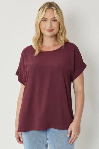 Burgundy Classic round neck short roll-up sleeve pullover top. Single button keyhole closure at back. Unlined. Woven. Non-sheer. Lightweight.