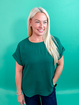 Hunter Green Classic round neck short roll-up sleeve pullover top. Single button keyhole closure at back. Unlined. Woven. Non-sheer. Lightweight.