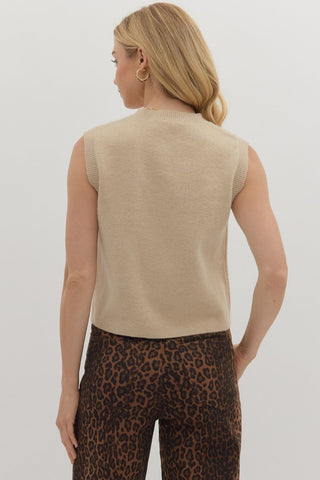 Solid sweater knit vest top featuring gold accent button closure at front. Pockets at front. Unlined. Knit. Non-sheer. Lightweight.