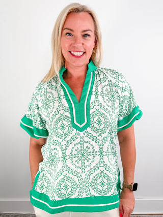 Moroccan print short bubble sleeve pullover top featuring contrast caftan-inspired structured neck band. Contrast accent outline slit hem. Unlined. Woven. Non-sheer. Lightweight.