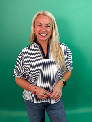 Stripe pattern high neck elasticated sleeve band dolman top featuring accented multicolor rib band split neck. Unlined. Woven. Non-sheer. Lightweight.