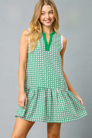 Sleeveless Mini Dress with Split V-Neckline, Drop Waist, Gathered Ruffle Hem and a Abstract Pink and Green Geo Pattern.