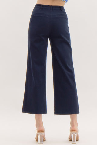 Solid high waisted wide leg ankle length pants featuring patch pockets at front. Faux pocket at back. Belt loops. Button and zipper closure at front. Unlined. Woven. Non-sheer. Lightweight.