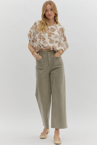 Solid high waisted wide leg ankle length pants featuring patch pockets at front. Faux pocket at back. Belt loops. Button and zipper closure at front. Unlined. Woven. Non-sheer. Lightweight.