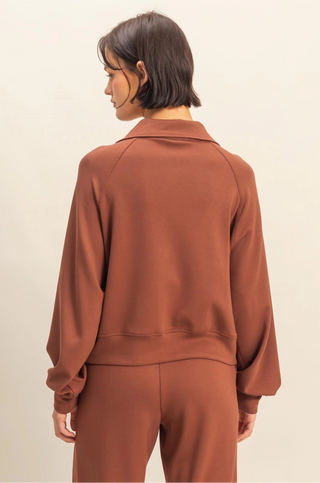 Chocolate brown cropped lightweight sweater with quarter zip, laydown collar, front pocket, and relaxed fit.