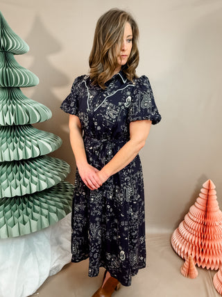 This midi shirt dress features an allover paisley print, contrast piping detail, puff sleeves and complete with a waist tie.