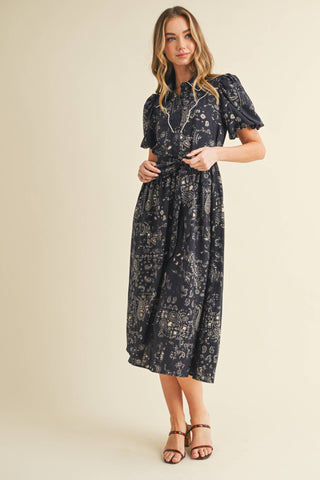 This midi shirt dress features an allover paisley print, contrast piping detail, puff sleeves and complete with a waist tie.