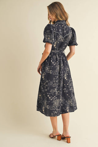 This midi shirt dress features an allover paisley print, contrast piping detail, puff sleeves and complete with a waist tie.