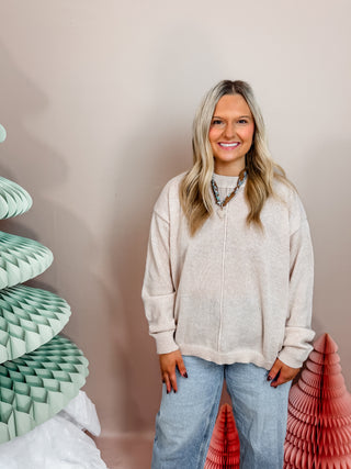 Cream soft knit sweater with cuffed sleeved and front seam