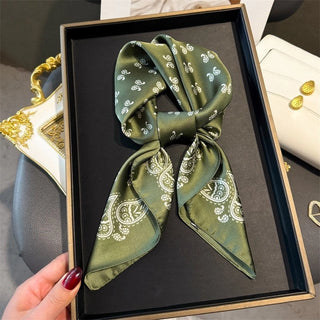 Green patterned scarf in a black box with gold accents