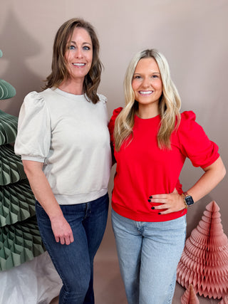 Knit top featuring a crew neckline, short puff sleeves with gathered shoulders, and ribbed cuffs and hem for a polished fit.