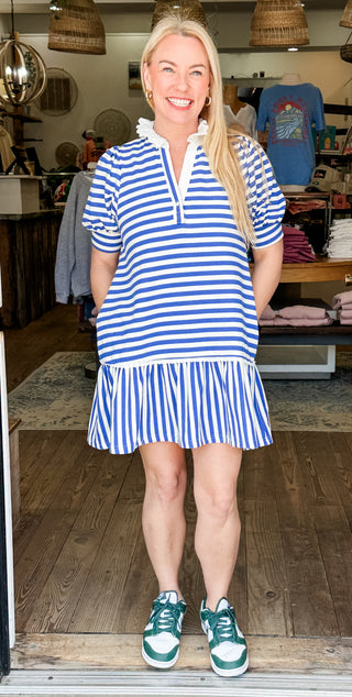 Blue and white striped dress with a notched neckline, puff sleeves, and a tiered ruffle hem.