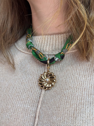 green scarf necklace with large gold flower charm with pearl center