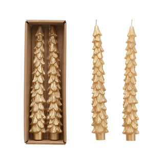 Set of gold tree-shaped candles with one candle outside its packaging on a white background