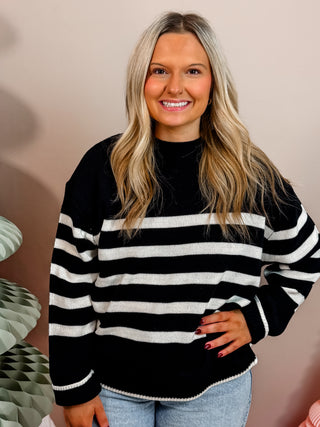 Black sweater with cream stripes, crew neckline, and easygoing fit. 