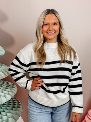 Off white sweater with black stripes, crew neckline, and easygoing fit. 