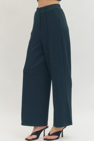 Solid knit wide leg pants featuring front center seam. Side pockets. Back elastic waist. Unlined. Knit. Non-sheer. Medium weight.