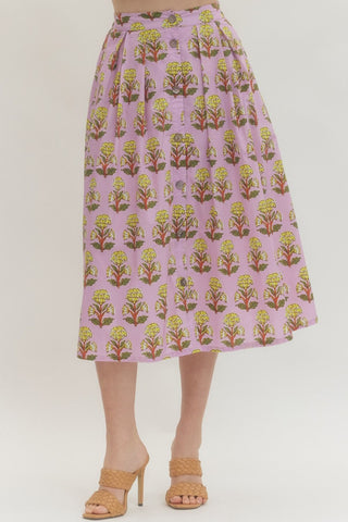 Floral print midi skirt featuring front button closure with gathered waist. Elastic at back waist. Side pockets. Lined. Woven. Non-sheer. Lightweight.