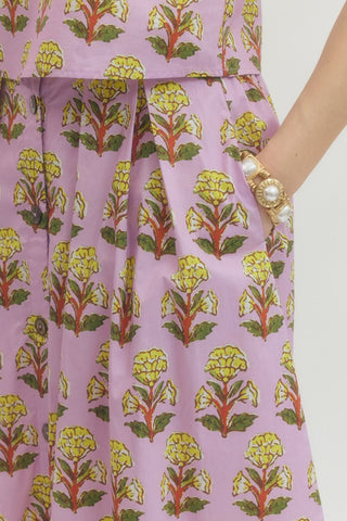 Floral print midi skirt featuring front button closure with gathered waist. Elastic at back waist. Side pockets. Lined. Woven. Non-sheer. Lightweight.