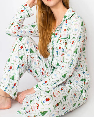 Person wearing a colorful pajama set with nutcracker waltz designs on a white background