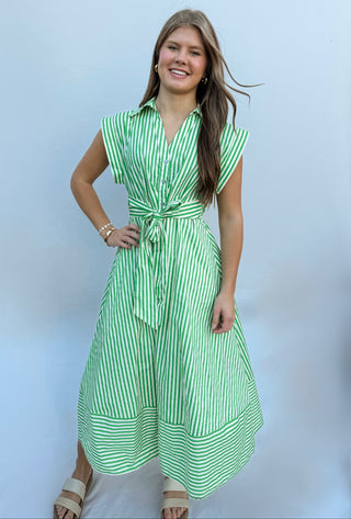 Striped cap sleeve midi dress featuring V-neck with self-tie detail at front and gathered waist. Side pockets. Lined. Woven. Non-sheer. Lightweight.