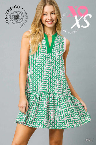 Sleeveless Mini Dress with Split V-Neckline, Drop Waist, Gathered Ruffle Hem and a Abstract Pink and Green Geo Pattern.