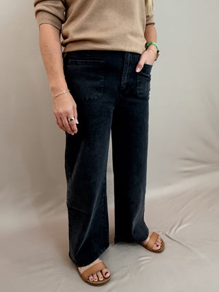Solid high waisted wide leg ankle length pants featuring patch pockets at front. Faux pocket at back. Belt loops. Button and zipper closure at front. Unlined. Woven. Non-sheer. Lightweight.