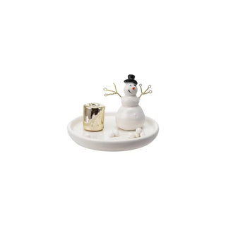 Small white snowman figurine with a gold candle holder on a white plate against a white background