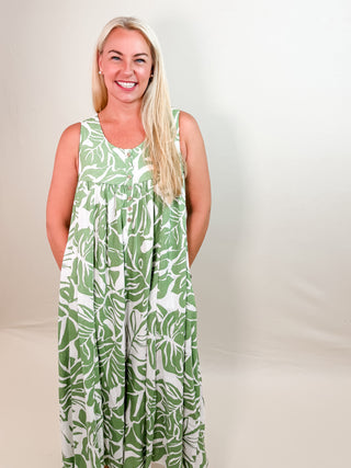 Sleeveless Green and White Tropical Print Jumpsuit with Thick Straps, Rounded Neckline, Button Front Closure, Pockets, Wide Leg Silhouette, and a Relaxed Fit