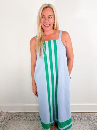 Solid straight neck pullover mini dress featuring contrasting accented framed border accents. Pockets at sides. Adjustable shoulder straps. Lined. Knit. Non-sheer. Lightweight.