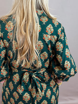 Botanical print half sleeve midi dress featuring self-tie belt at waist and button closure at front. Shirt collar. Buttoned cuffs. Lined. Woven. Non-sheer. Medium weight.