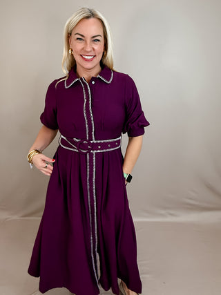 Solid short puff sleeve midi dress featuring contrast embroidered blanket stitch trim and removable belt at waist. Button closure at front. Side pockets. Lined. Woven. Non-sheer. Lightweight.